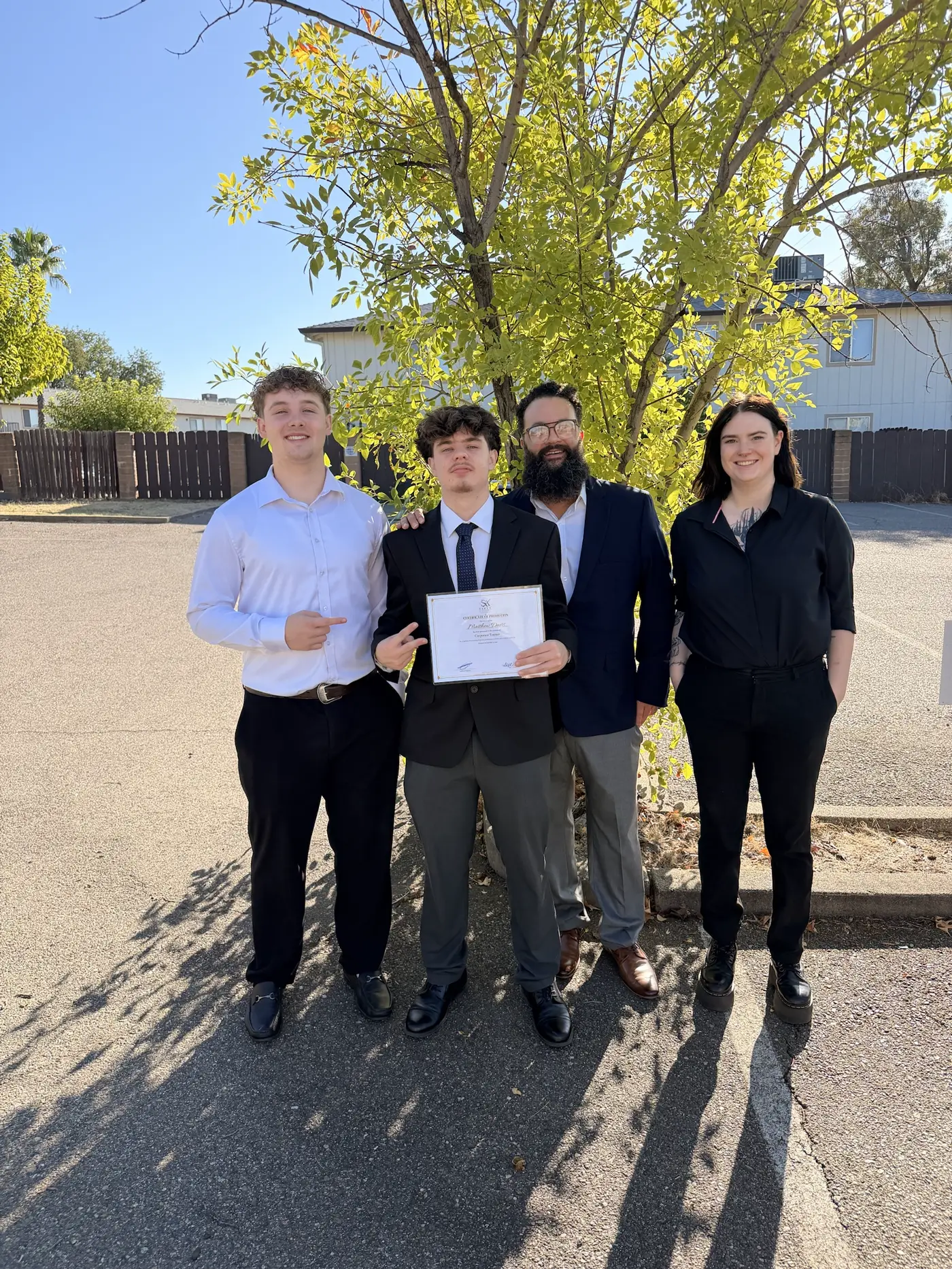 A rep holding his promotion certificate with his team